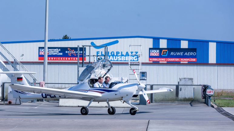 Kleinflugzeug vor dem Hangar